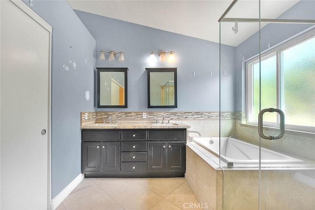 bathroom with tiled tub, tile patterned flooring, vanity, and vaulted ceiling