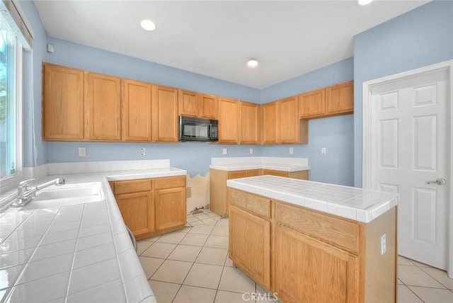 kitchen featuring tile counters, a center island, and a healthy amount of sunlight