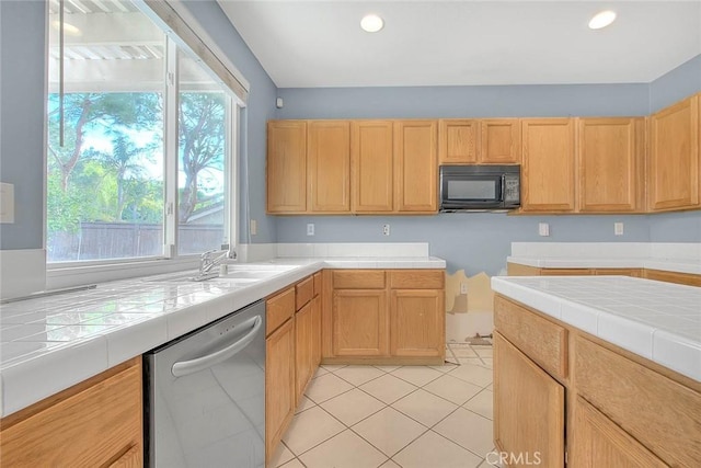 kitchen featuring tile counters, dishwasher, plenty of natural light, and sink