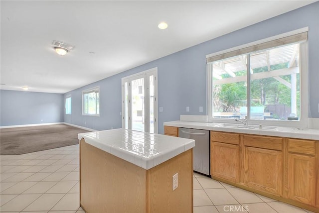 kitchen with tile countertops, a wealth of natural light, a center island, and stainless steel dishwasher