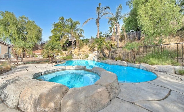 view of pool with an in ground hot tub