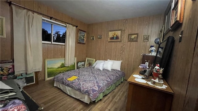 bedroom with hardwood / wood-style floors and wooden walls