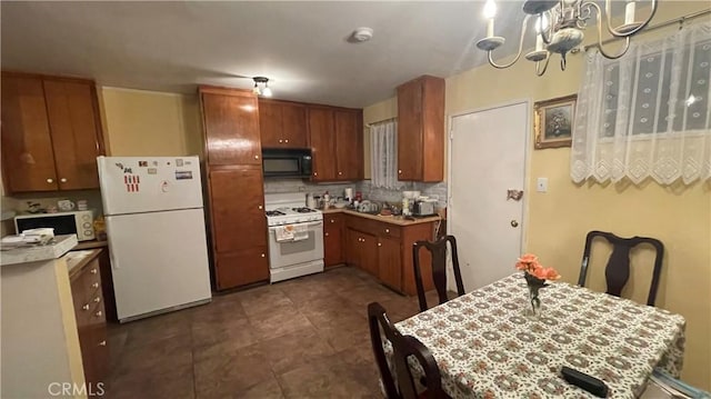 kitchen featuring decorative backsplash, white appliances, and a chandelier