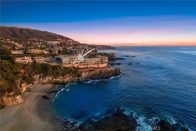 aerial view at dusk featuring a beach view and a water and mountain view