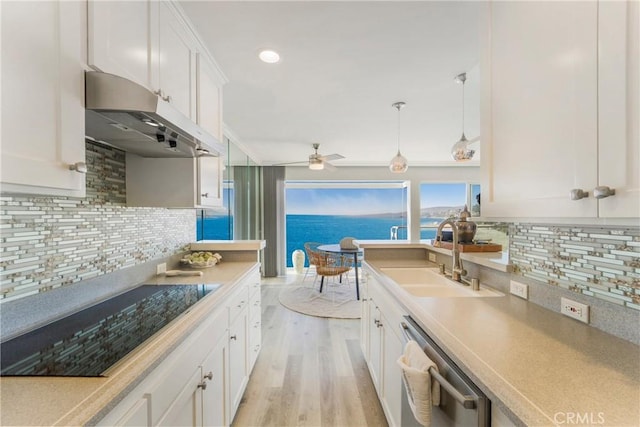 kitchen with decorative light fixtures, dishwasher, white cabinets, black electric stovetop, and a water view