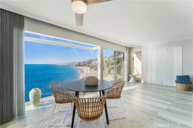 sunroom featuring a water view