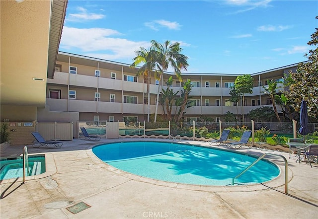community pool with fence and a patio area