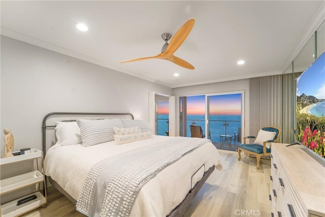 bedroom featuring a water view, ornamental molding, light hardwood / wood-style flooring, and access to outside