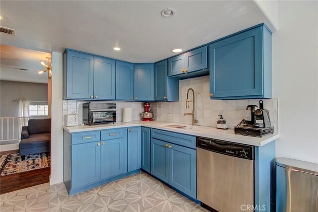 kitchen featuring stainless steel dishwasher, light hardwood / wood-style floors, blue cabinets, and sink