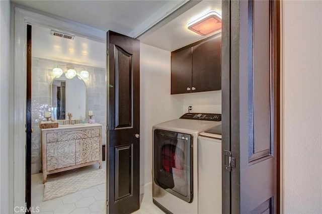 washroom featuring washer and clothes dryer, cabinets, light tile patterned floors, and sink