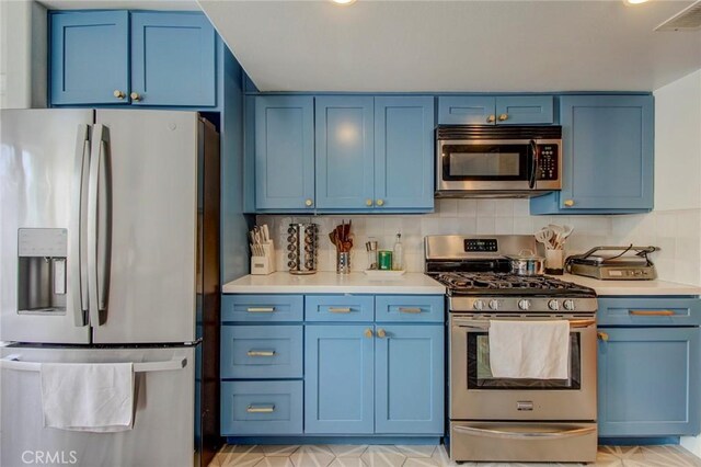 kitchen with tasteful backsplash, blue cabinetry, and appliances with stainless steel finishes