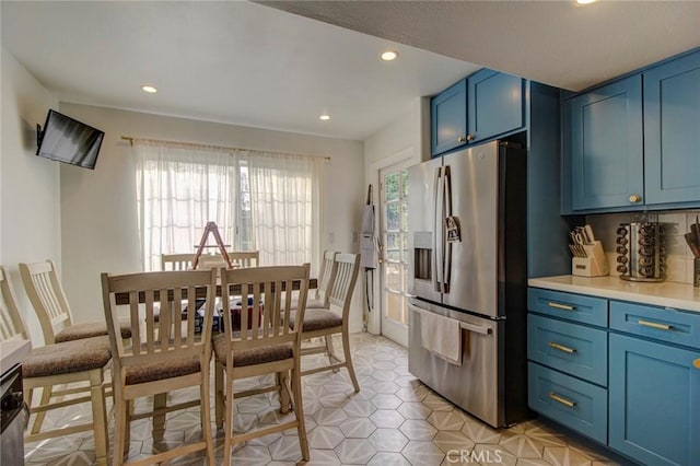 kitchen featuring blue cabinetry and stainless steel fridge