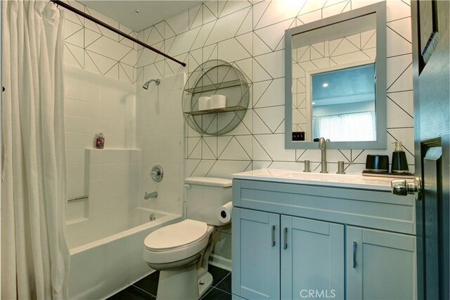 full bathroom with vanity, shower / bath combination with curtain, tile patterned flooring, toilet, and tile walls