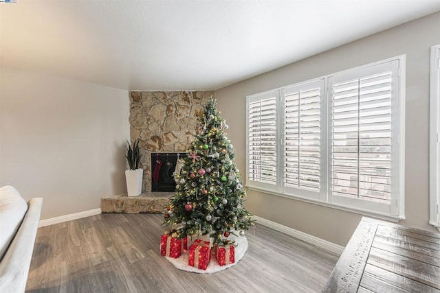 dining area with hardwood / wood-style flooring and a stone fireplace