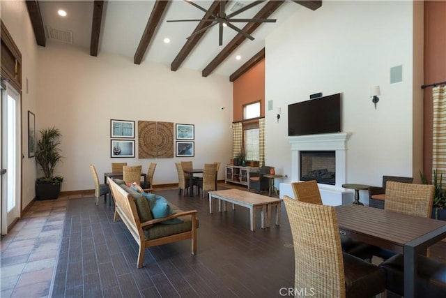 living room with beamed ceiling, dark hardwood / wood-style flooring, and high vaulted ceiling