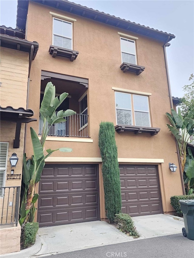 view of front of property featuring a balcony and a garage