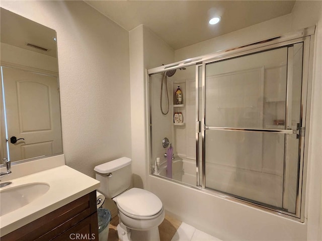 full bathroom featuring tile patterned flooring, vanity, toilet, and bath / shower combo with glass door