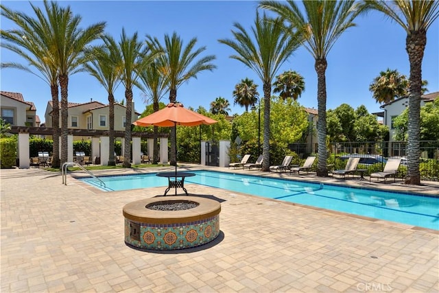 view of pool with an outdoor fire pit and a patio