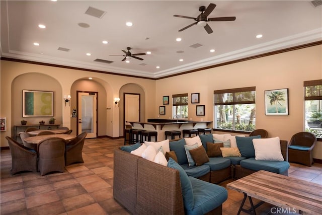 living room with ceiling fan and ornamental molding