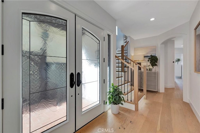 entryway with french doors and light hardwood / wood-style floors