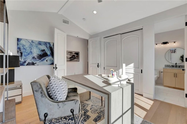 office space with light hardwood / wood-style flooring, lofted ceiling, and sink