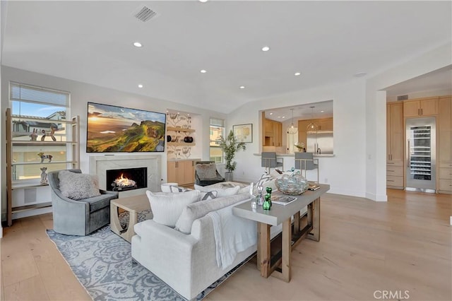 living room featuring a premium fireplace and light hardwood / wood-style floors