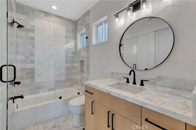 full bathroom with vanity, toilet, and shower / bath combination with glass door