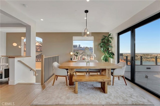 dining room featuring a water view and light hardwood / wood-style flooring