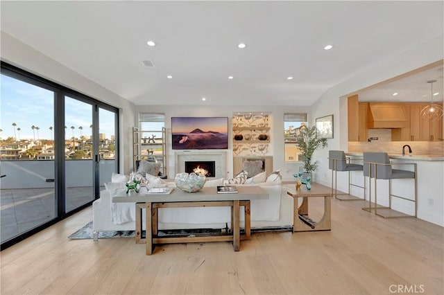 living room featuring light wood-type flooring and sink