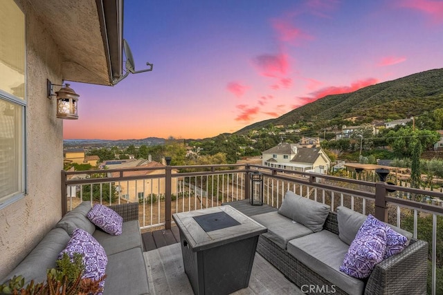 deck at dusk featuring a mountain view and an outdoor hangout area