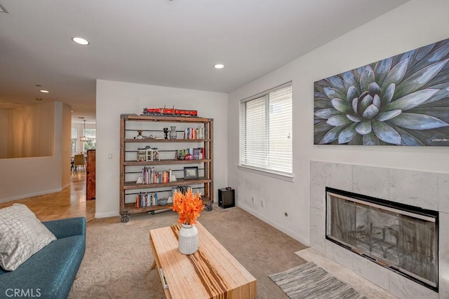 carpeted living room featuring a tile fireplace