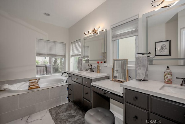 bathroom with a relaxing tiled tub and vanity