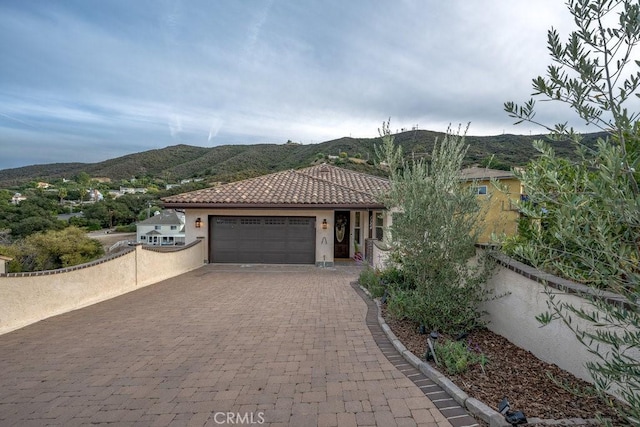 view of front of home with a mountain view and a garage