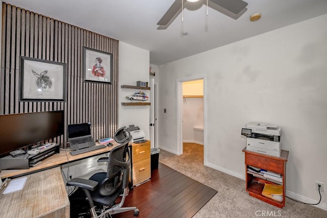 carpeted office space with ceiling fan