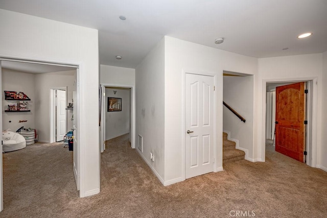 hallway featuring light colored carpet