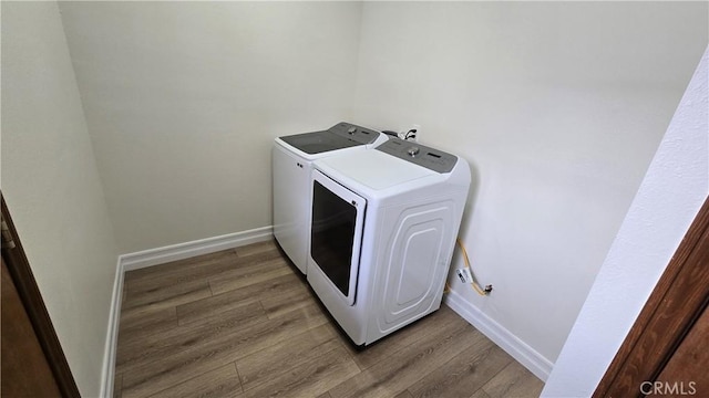 laundry room featuring hardwood / wood-style floors and washing machine and dryer