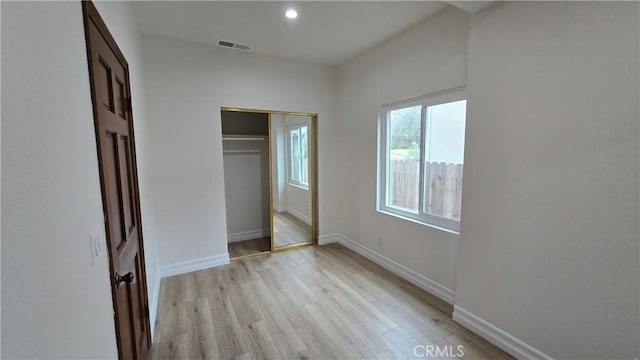 unfurnished bedroom featuring light wood-type flooring and a closet