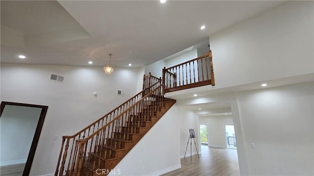 stairs featuring a notable chandelier and hardwood / wood-style flooring