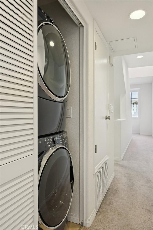 washroom featuring light carpet and stacked washer and dryer