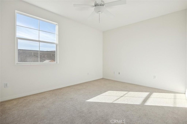 carpeted spare room with ceiling fan