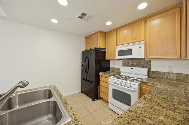 kitchen featuring stone counters, sink, white appliances, light brown cabinetry, and light tile patterned floors