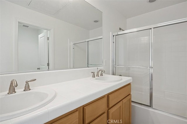 bathroom with combined bath / shower with glass door and vanity