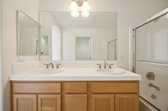 bathroom featuring vanity and combined bath / shower with glass door