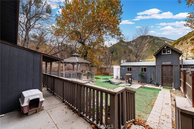 exterior space featuring a gazebo, a deck with mountain view, and a storage unit