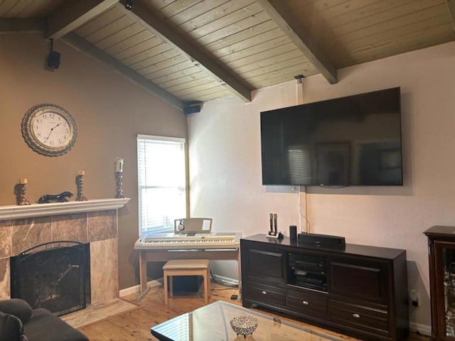 living room featuring lofted ceiling with beams, a fireplace, and light hardwood / wood-style floors