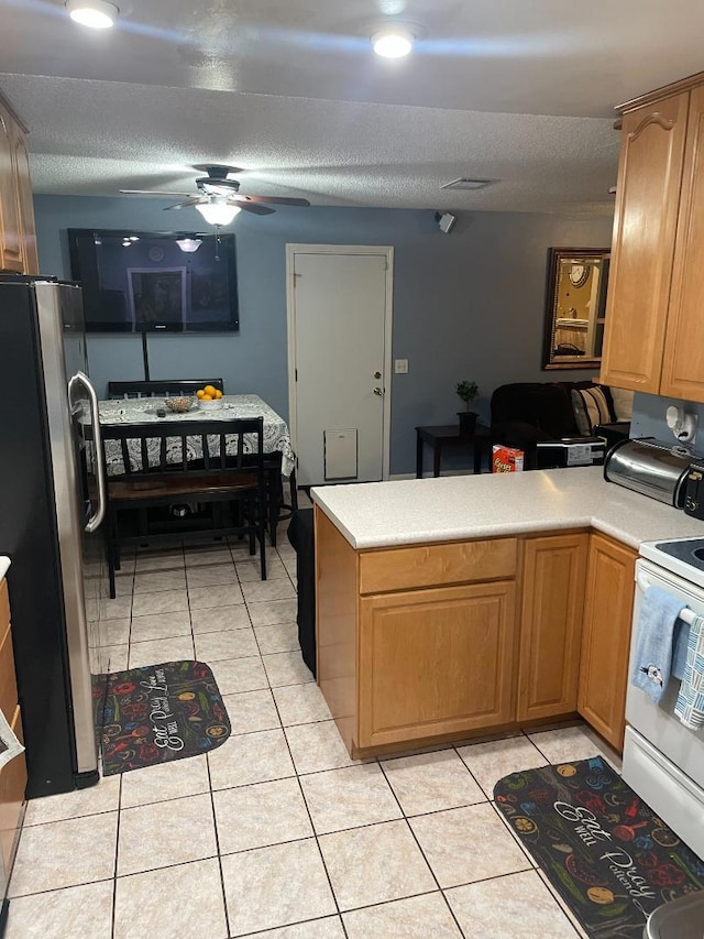 kitchen featuring white range with electric cooktop, light tile patterned flooring, stainless steel refrigerator, ceiling fan, and kitchen peninsula