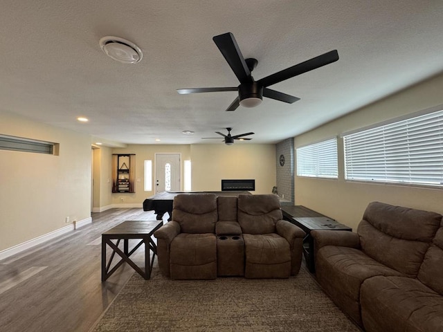 home theater featuring ceiling fan, a healthy amount of sunlight, and wood-type flooring