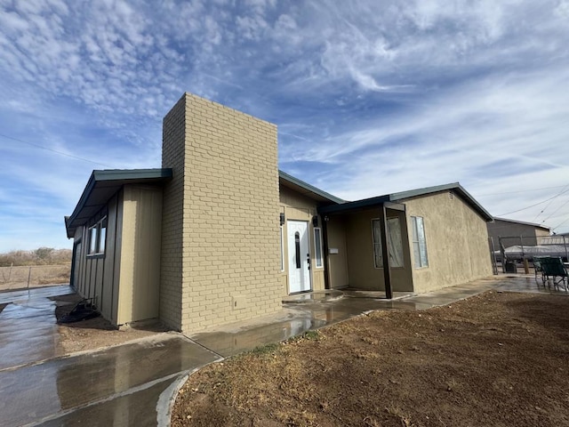 view of side of home with a patio area