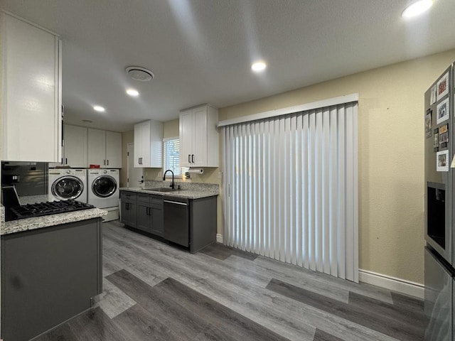 kitchen featuring gray cabinets, separate washer and dryer, stainless steel dishwasher, white cabinets, and sink