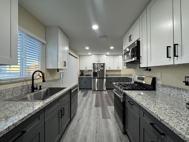 kitchen featuring appliances with stainless steel finishes, white cabinets, and sink